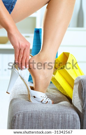 Closeup photo of female leg and hands. Woman fitting her high heel shoe.