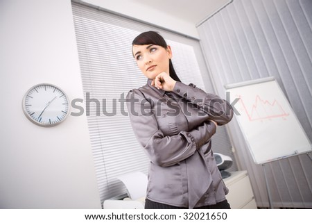 Young businesswoman thinking in office preparing for her presentation beside a whiteboard.