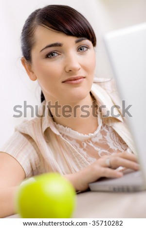 Closeup portrait of happy young women browsing internet on laptop computer at home, smiling.