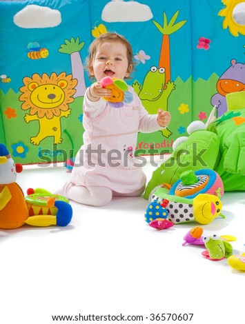 Happy baby playing with soft toys, smiling, isolated on white background.