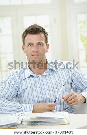 Man working at home, sitting at table in living room.