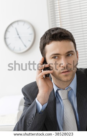 Worried businessman talkin on mobile phone.