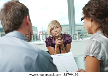 Woman applicant craving for job during job interview. Over the shoulder view.