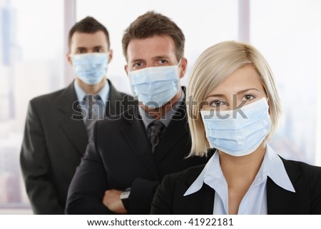 Business people fearing h1n1 swine flu virus wearing protective face mask and standing in a row.