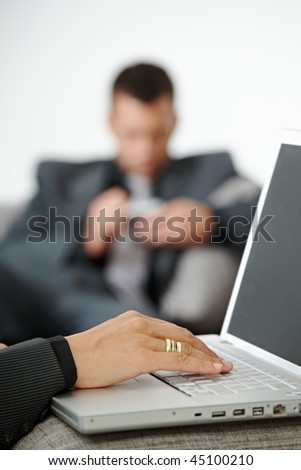 People at office. Businesswoman writing notes to laptop computer. Focus on typing  female hand.