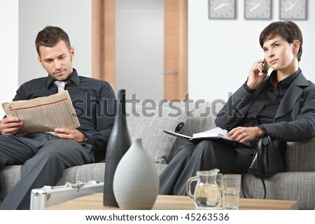 Business people sitting on sofa at office anteroom waiting.