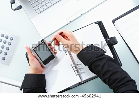 Female hand using touch screen handheld computer with stylus.