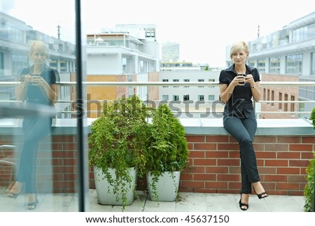 Businesswoman having break on office terrace outdoor drinking coffee.