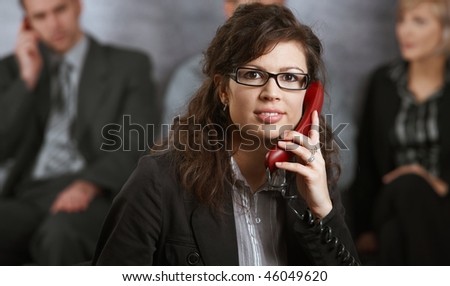 Closeup portrait of young businesswoman talking on landline phone, smiling.