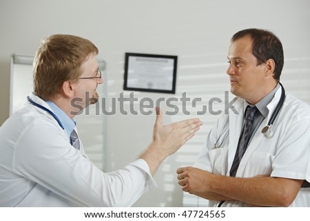 Medical office - middle-aged male doctors having consultation at office.