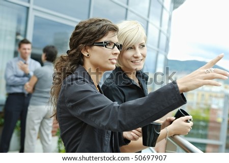 Businesswomen having break on office terrace outdoor drinking coffee.