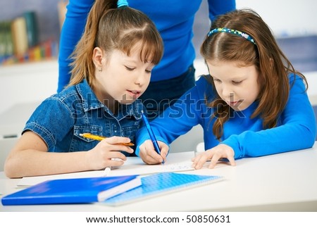 stock photo : Schoolgirls learning together in primary school classroom.