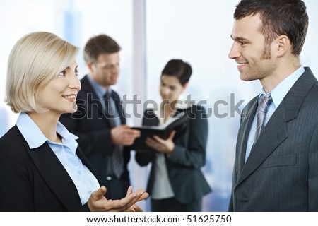images of people talking to each other. stock photo : Standing business people talking in office smiling at each 