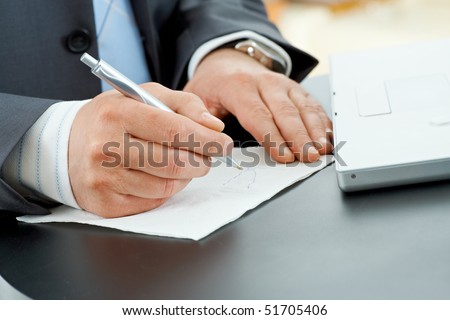 Hands of businessman writing notes on paper napkin with pen.