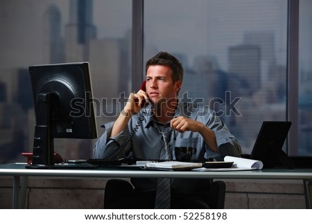Tired businessman on call  working late holding glasses looking at screen doing overtime in office at night.