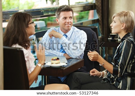 Young businessman and businesswomenhaving a meeting in cafe.