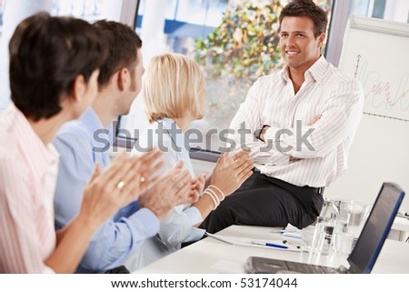 Business people clapping at the end of business presentation, celebrating business success.
