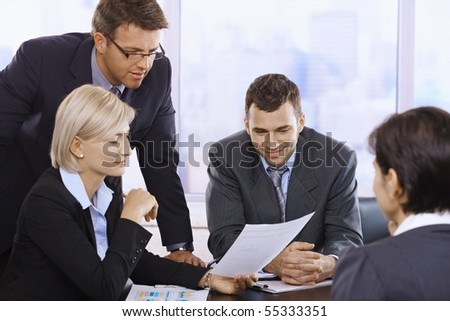 Businesspeople reviewing contract at meeting in office.?