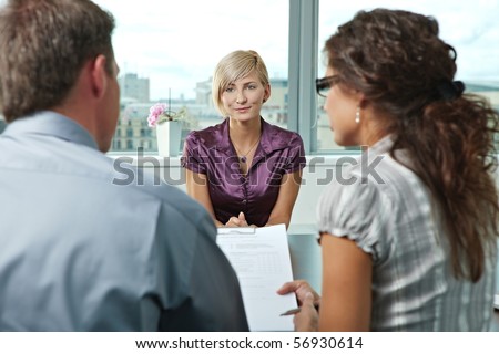 Attractive woman applicant talking during job interview. Over the shoulder view.