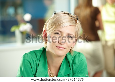 Closeup portrait of attractive young businesswoman wearing green shirt, smiling.