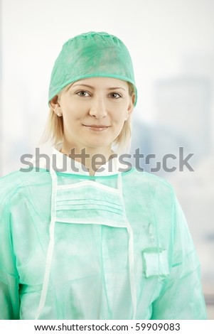 Portrait of female medical doctor wearing scrub suit, smiling at camera.?