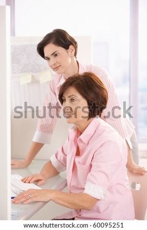 Female coworkers working together with computer in office.?