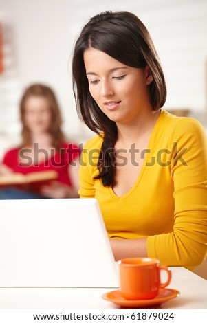 Teen girl using laptop computer browsing internet at home,?