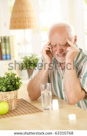 stock-photo-pensioner-suffering-from-migraine-holding-head-with-closed-eyes-taking-painkiller-at-home-63310768.jpg