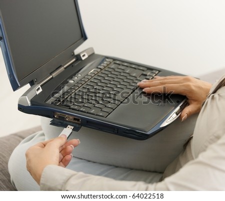 Closeup of plugging in flash drive into laptop computer. Copyspace on blank screen.?