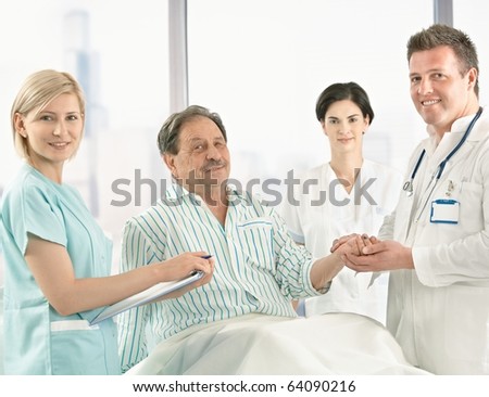  Of Elderly Patient Sitting On Hospital Bed In Pyjama, Holding Hands.