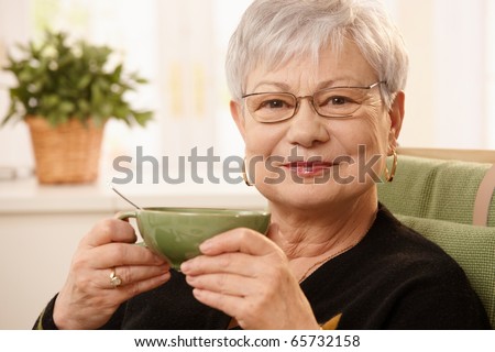 stock photo Closeup portrait of mature lady sitting at home holding teacup