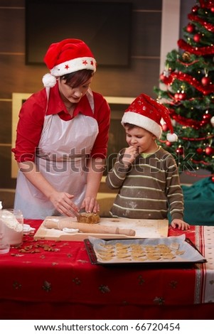 Mother and small son getting ready for christmas, baking cake together.?
