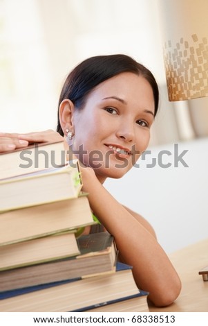 Portrait of smiling college student young woman posing with books.