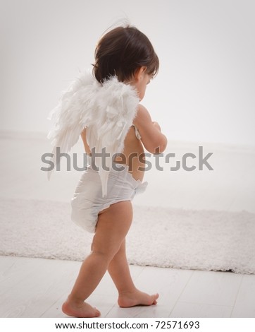 One year old baby girl wearing white angel wings. Back view. Isolated on white background.?