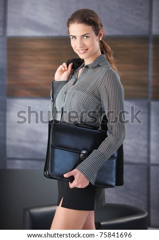 Pretty businesswoman smiling happily, holding briefcase, wearing mini skirt, going to job interview.?
