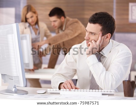 Handsome young man participating at training course, using computer.?