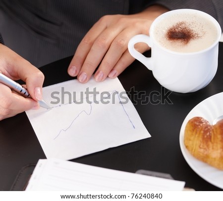 Working, drawing diagram, having coffee and croissant.?