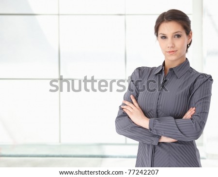 Portrait of young caucasian businesswoman standing. looking at camera, smiling. Huge copy space on left.?