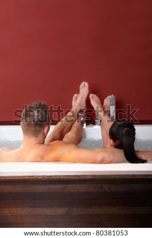 Couple in wellness jacuzzi with feet up, relaxing.?