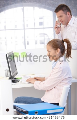 Casual office workers busy in office, using computer and phone, working.?