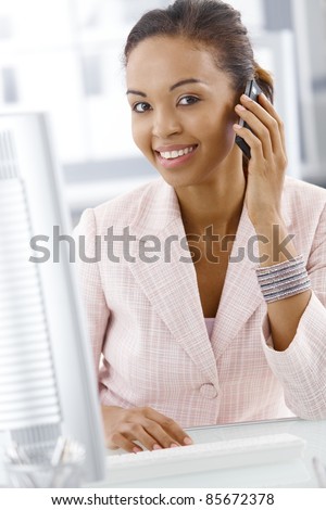 Portrait of happy office worker woman on mobile phone call, smiling at camera.?
