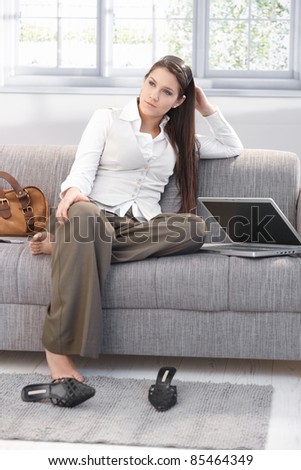 Weary businesswoman sitting on sofa after work, resting.?