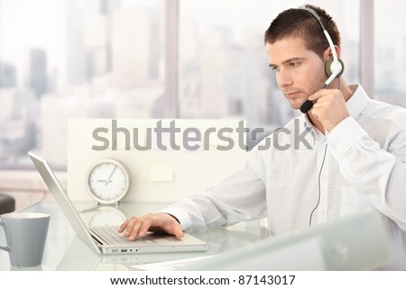 Male customer service operator working in bright office.?