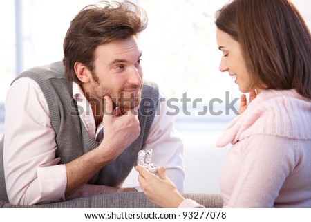 Handsome man proposing to woman, giving engagement ring, smiling.?