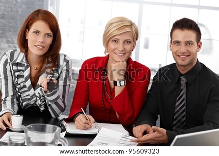 Portrait of smiling confident smart businesspeople at meeting, smiling at camera.?