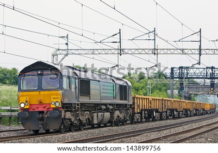 TRING, UK - JUNE 6: An early morning DRS spoil train passes Tring loops on June 6, 2013 in Tring. DRS is one of the largest UK rail freight operators with over 90% of its trains arriving on time