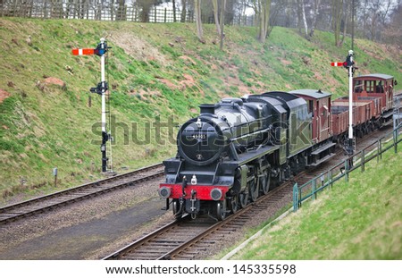 SWITHLAND, UK - MARCH 26: Black5 steam loco, 45305, brings a freight train down Rothley embankment on March 26, 2011 in Swithland. Between 1934 & 1951, 842 of the 4-6-0 Stanier locos were produced