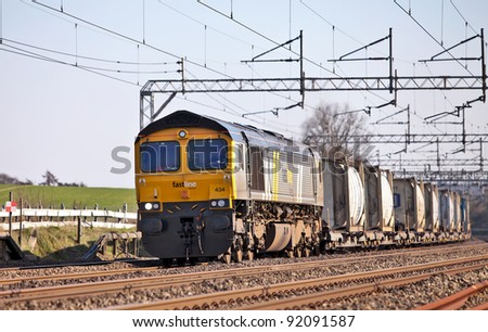 COW ROAST, ENGLAND - MARCH 23: A freight train of bulk liquid tanks passes north along WCML on March 23, 2010 at Cow Roast. The largest UK freight trains remove up to 160 HGV journeys from the road