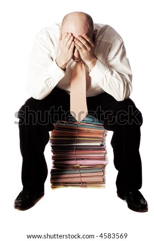 Man sitting on pile of files in shirt and tie and head in hands, eyes covered, isolated on white background