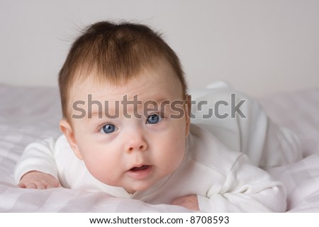 Baby infant girl on white cloth. White background.